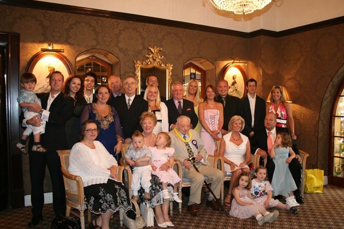 The photograph of a large family gathered in a function room that the painting was made from