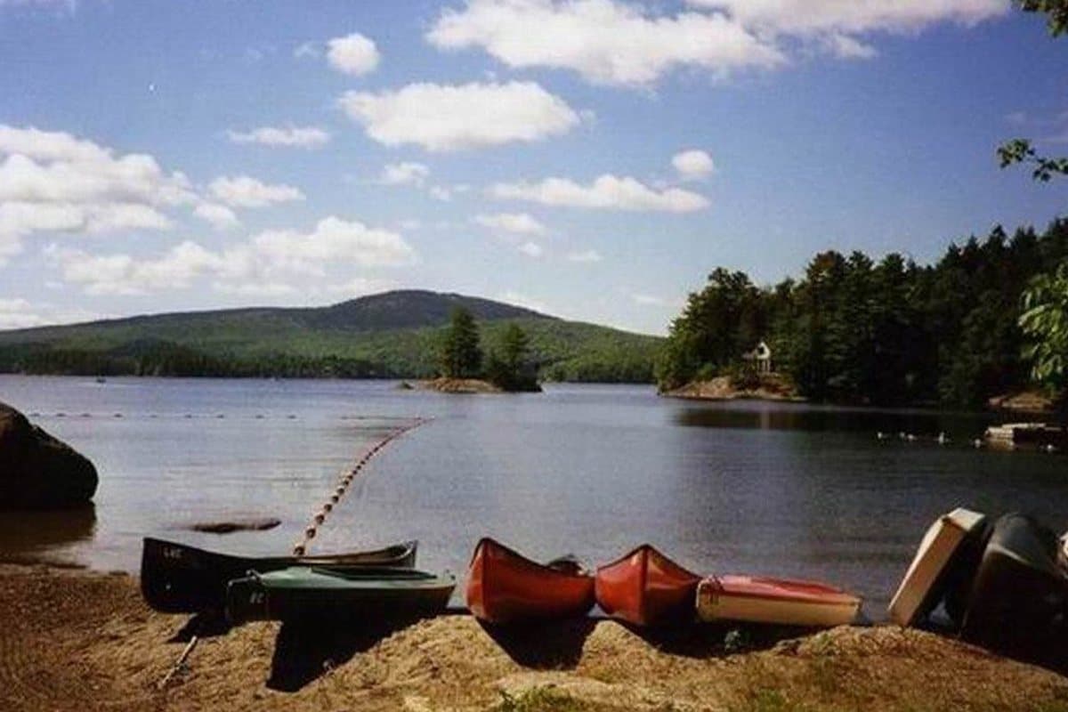 The photograph of a lake shore with canoes pulled up on the sand that the painting was made from