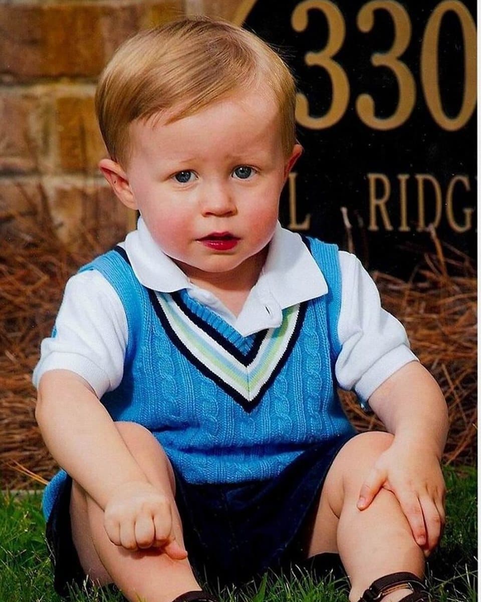 The photograph of a toddler sitting on the grass that the painting was made from