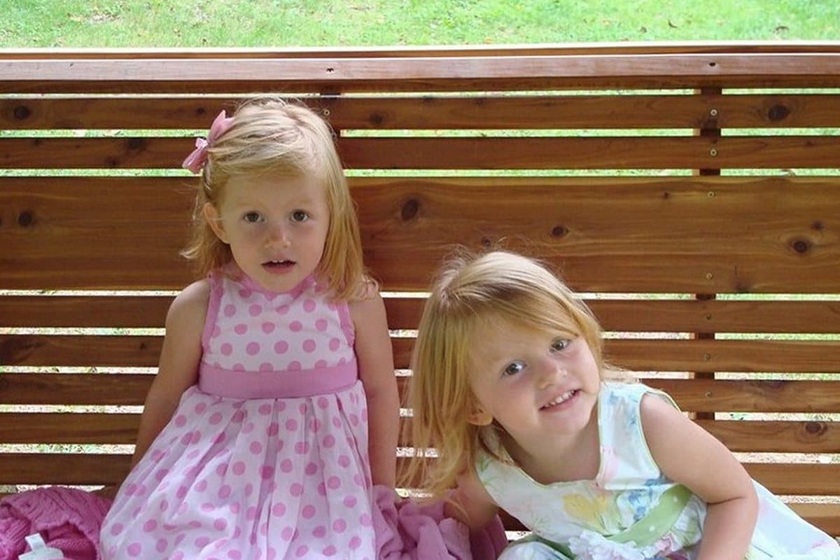 The photograph of two little girls on a garden bench that the painting was made from