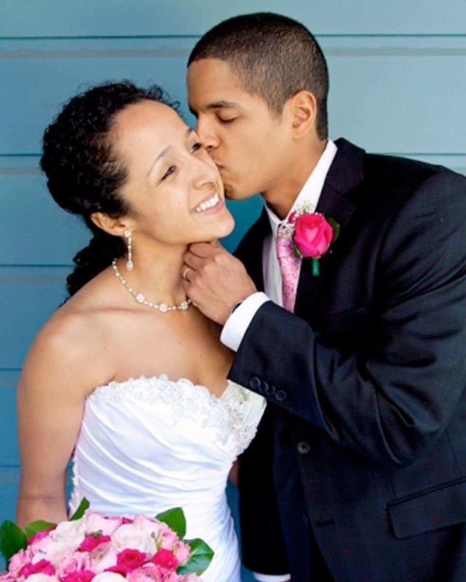 The photograph of a groom kissing his bride on the cheek that the painting was made from